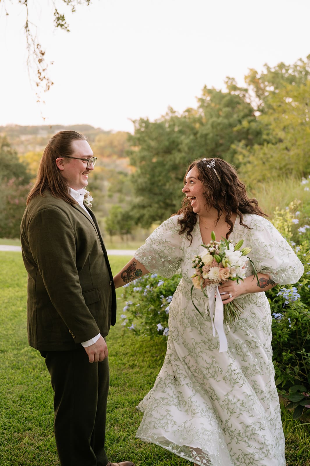 A couple dressed in formal attire takes elopement photos while standing outdoors on a sunny day for a texas hill country elopement