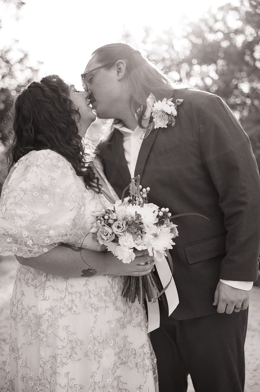 A couple dressed in formal attire takes elopement photos while standing outdoors on a sunny day for a texas hill country elopement 