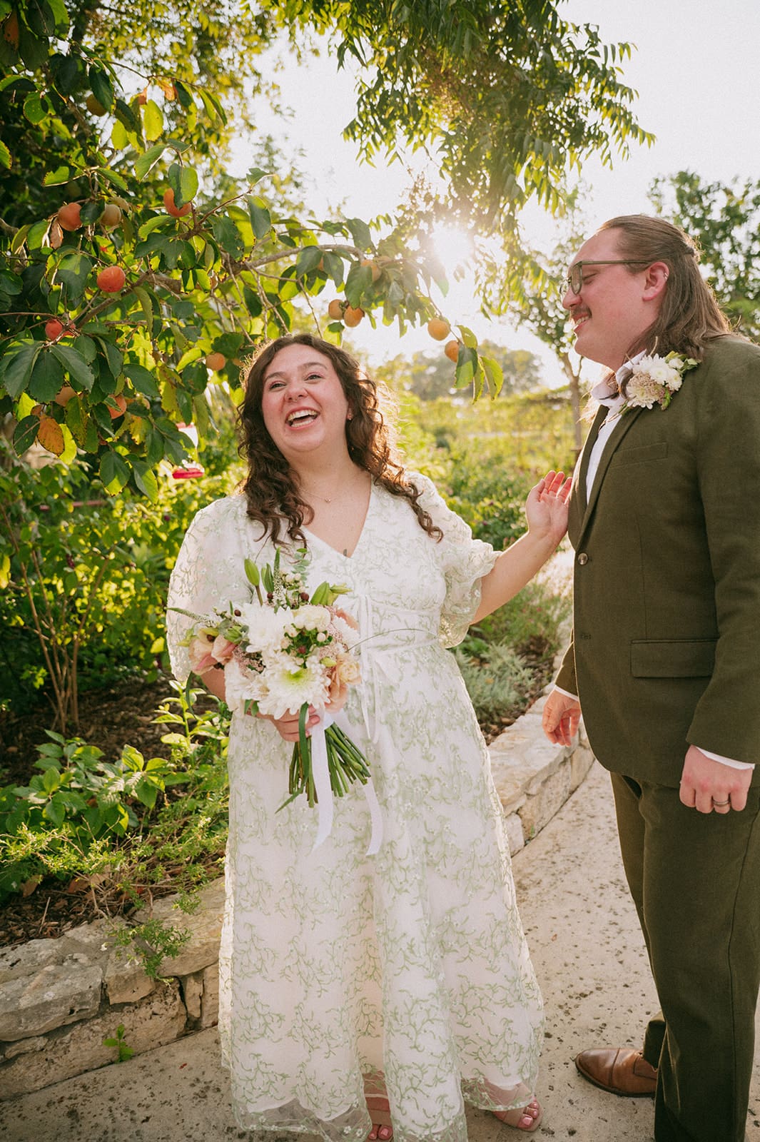 A couple dressed in formal attire takes elopement photos while standing outdoors on a sunny day for a texas hill country elopement 