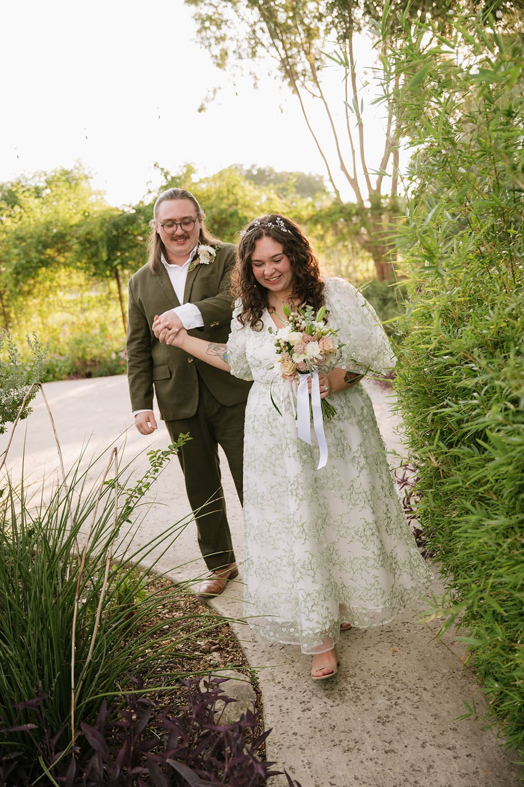 A couple dressed in formal attire takes elopement photos while standing outdoors on a sunny day for a texas hill country elopement