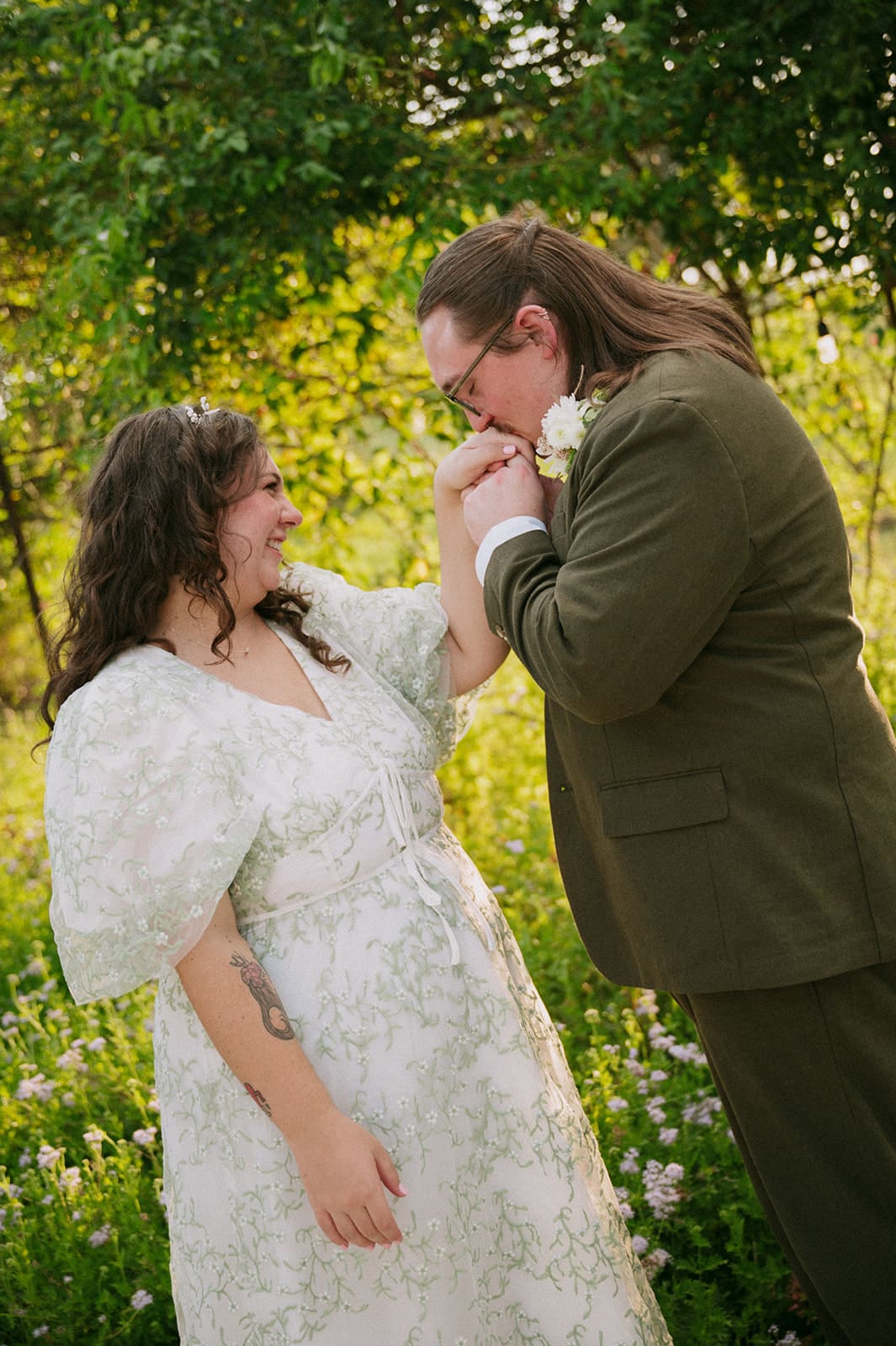 A couple dressed in formal attire takes elopement photos while standing outdoors on a sunny day for a texas hill country elopement