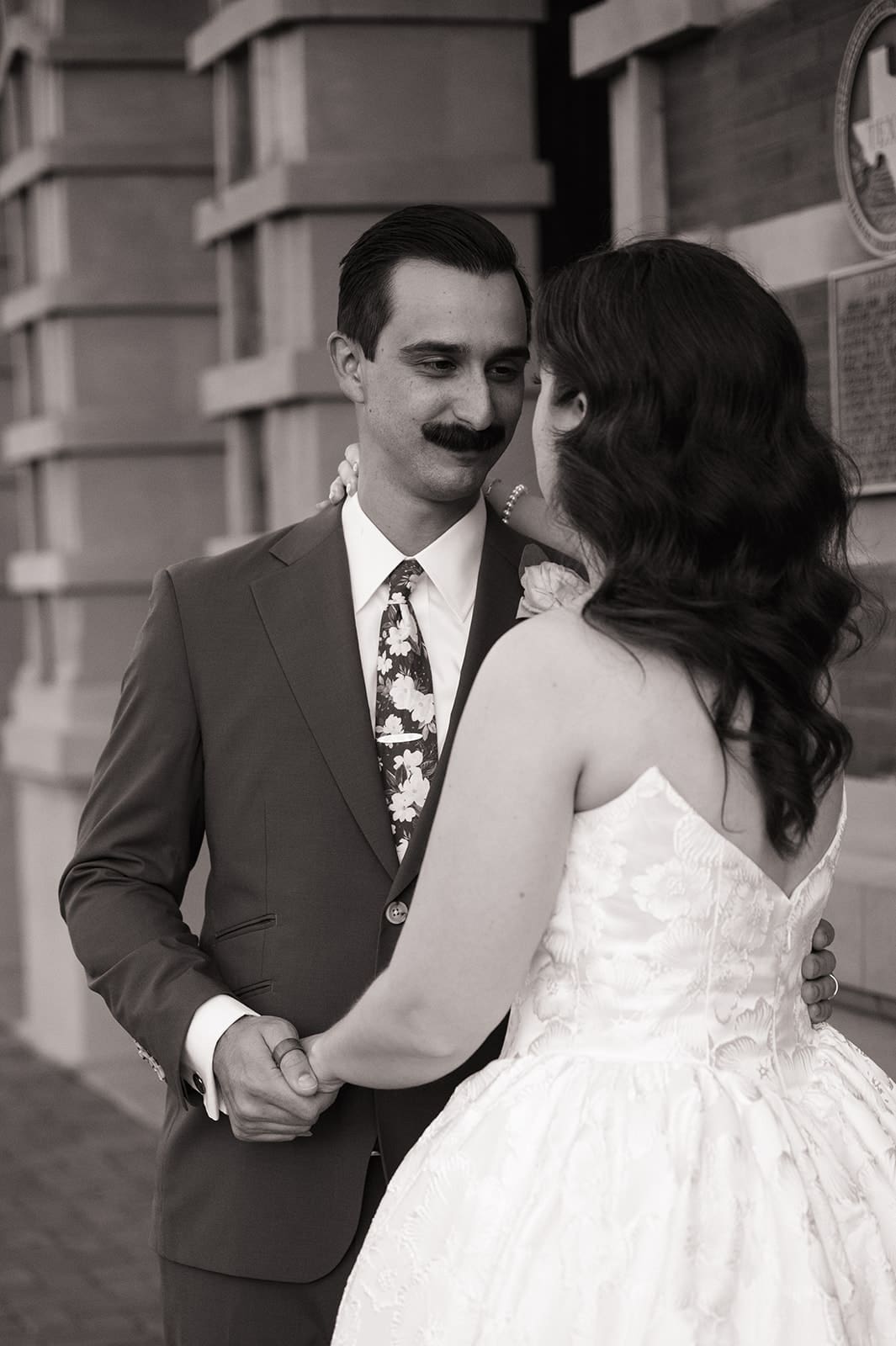 bride and groom take wedding portaits outside of The Ashton Depot in Fort Worth