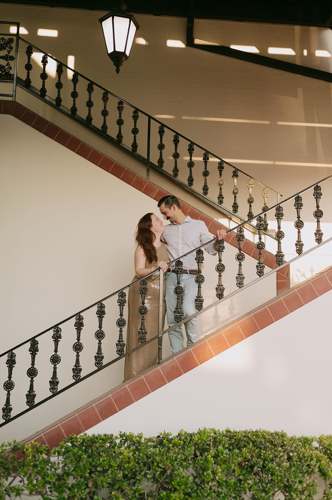 bride and groom smiling at each other on a brick staircase for rehearsal dinner portraits at the ashton depot
