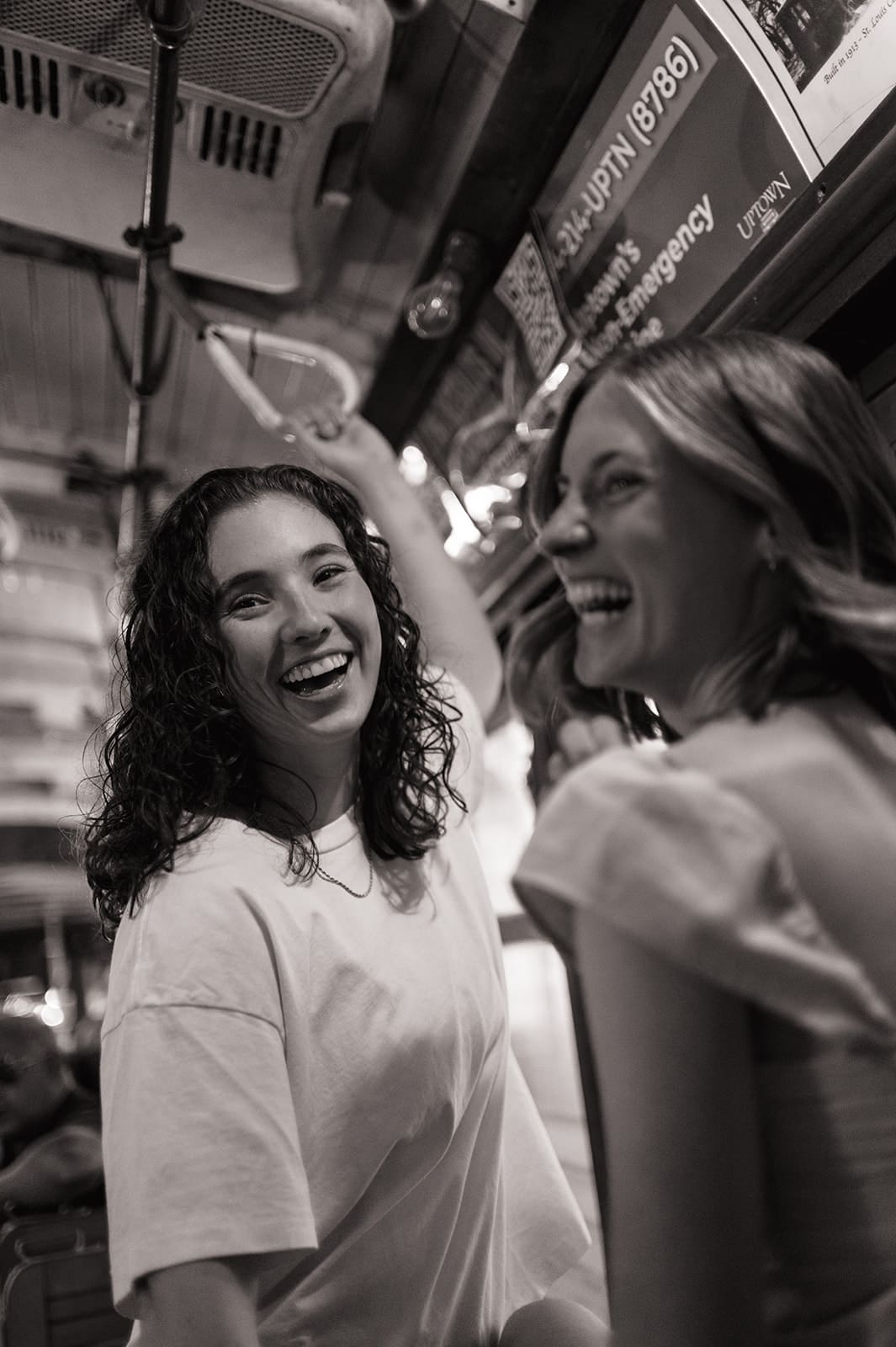 Two people sit closely together on a wooden bench, facing each other and making eye contact in a relaxed indoor setting for unique engagement photos