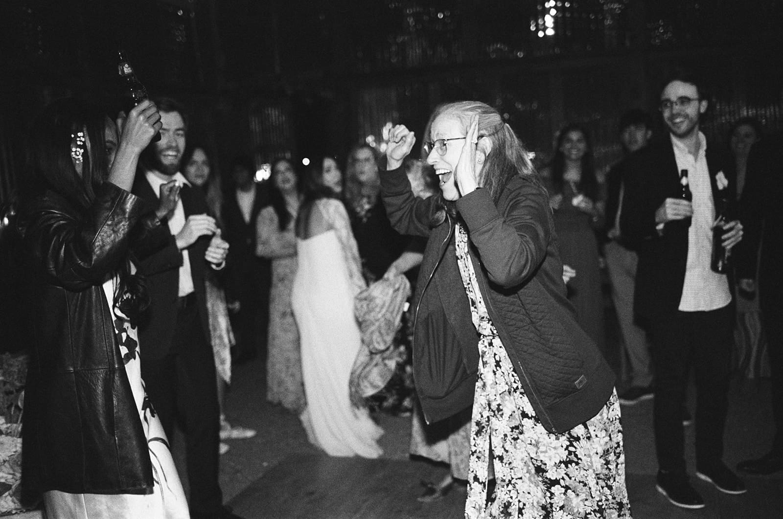 a group of people dancing on the dance floor at a wedding