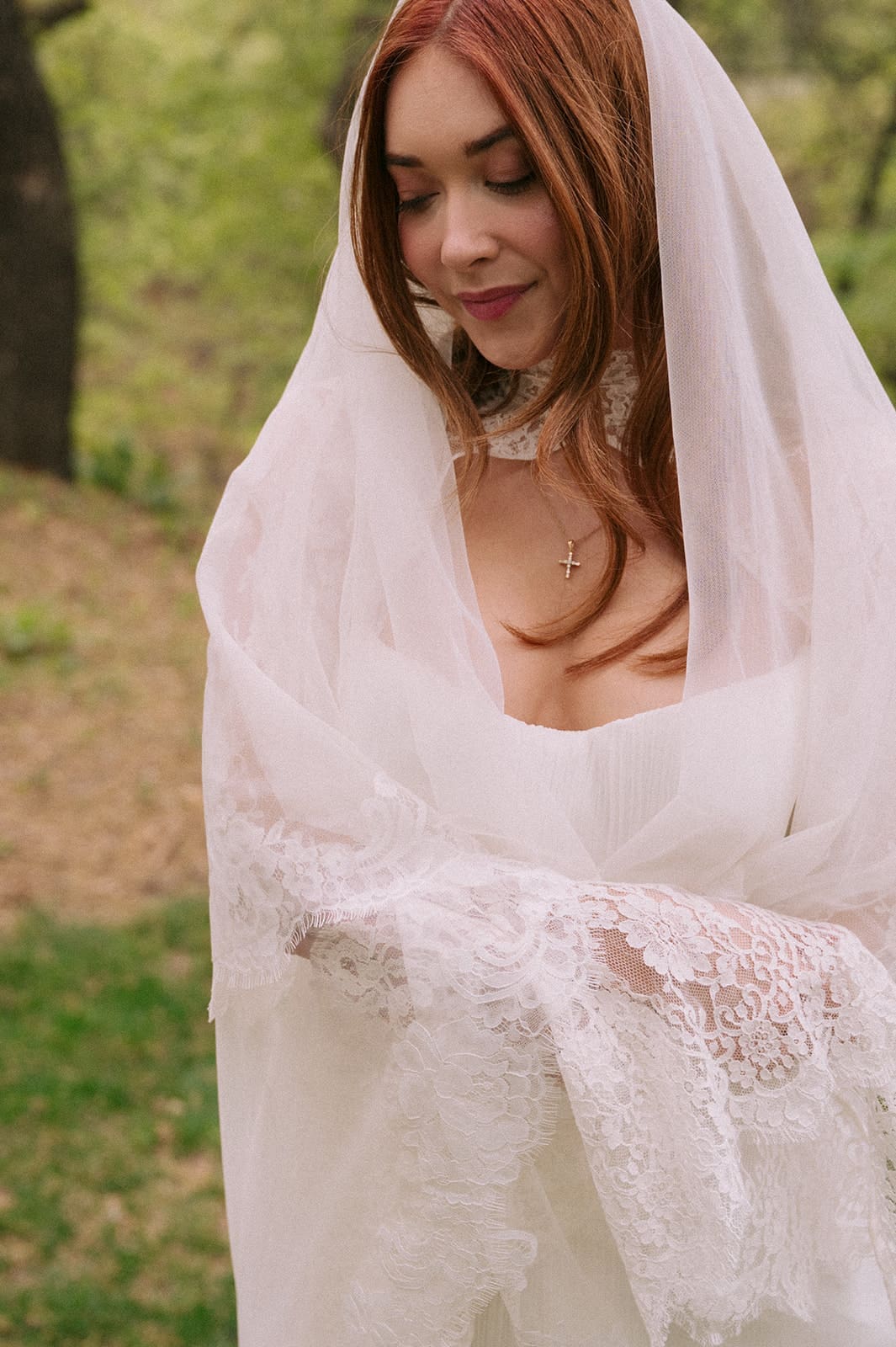 A bride and groom stand facing each other outdoors, holding hands, with an officiant reading between them during a wedding ceremony at An Intimate Backyard Wedding in Dallas