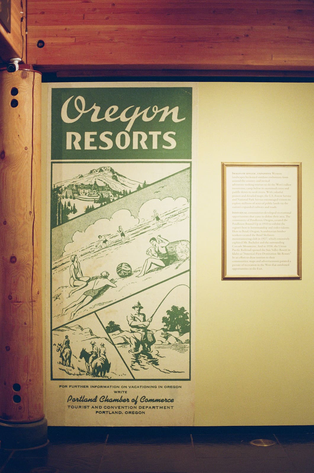 Large vintage-style poster titled “Oregon Resorts” with illustrations of outdoor activities, next to a framed text panel on a light green wall.